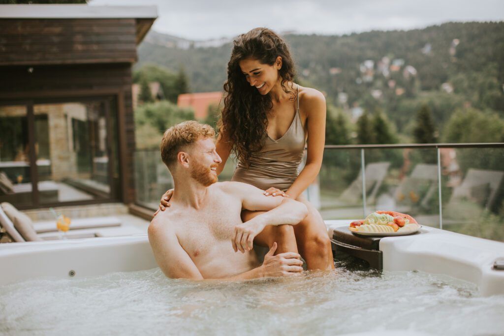 Attractive young couple enjoying in outdoor hot tub on vacation in Asheville NC